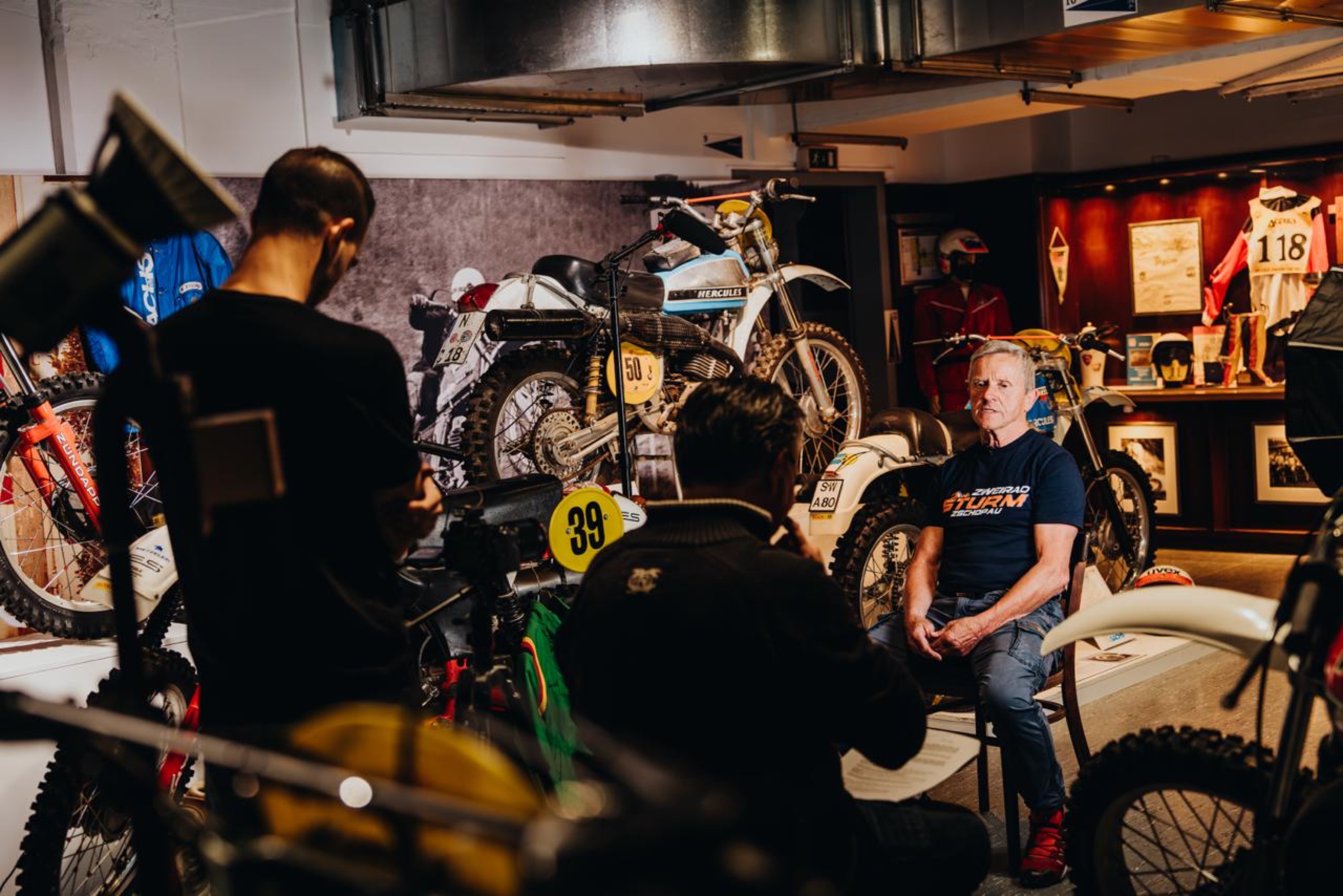 Set der Webserie 6DAYS: ein Fahrer im Interview in einer historischen Werkstatt
